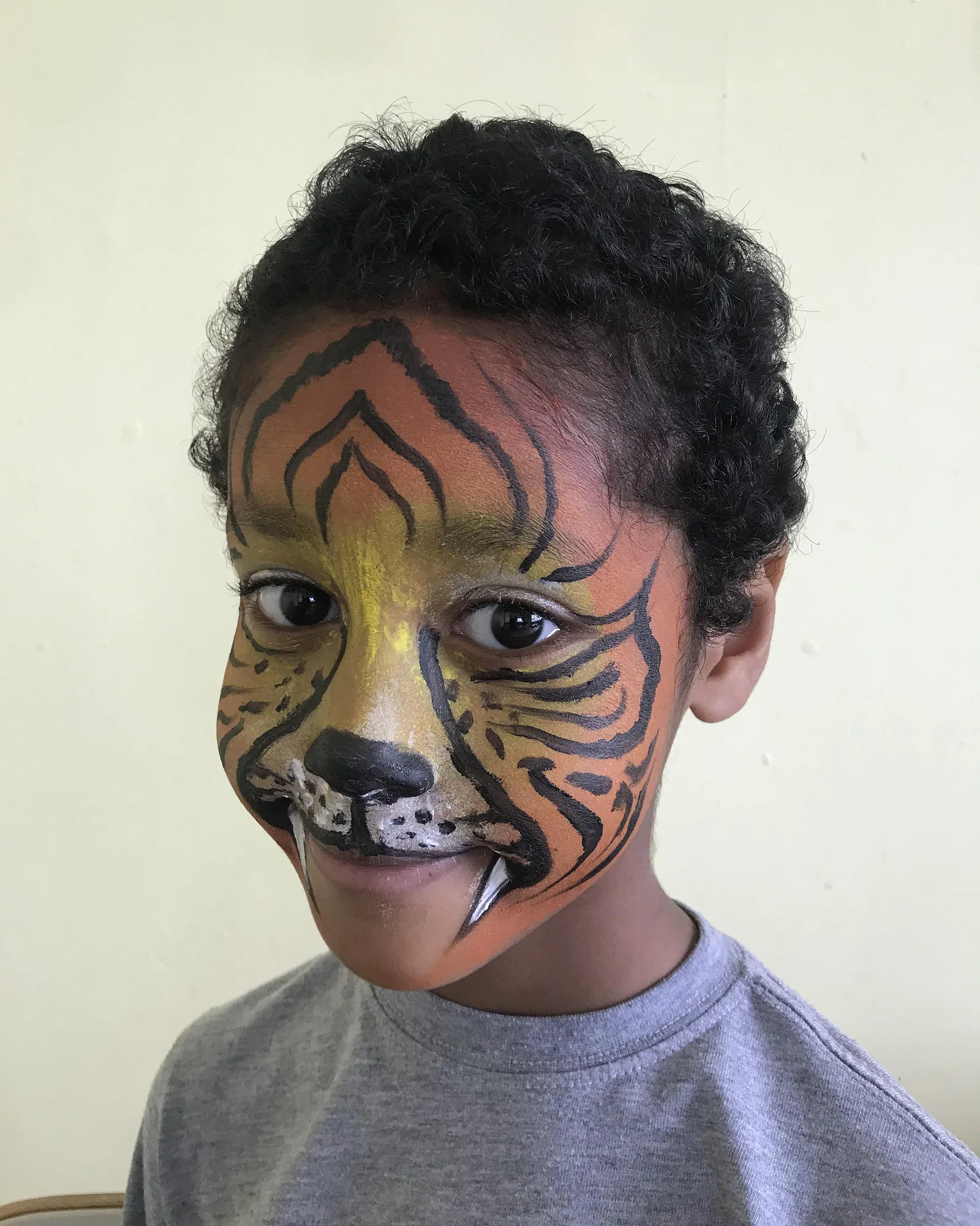 Piya's tiger face-painting design with fangs, side profile